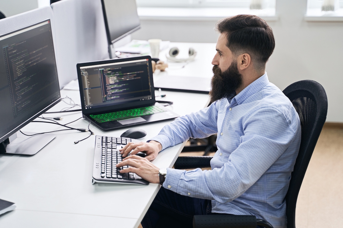 An IT support employee running diagnostics on a laptop computer.